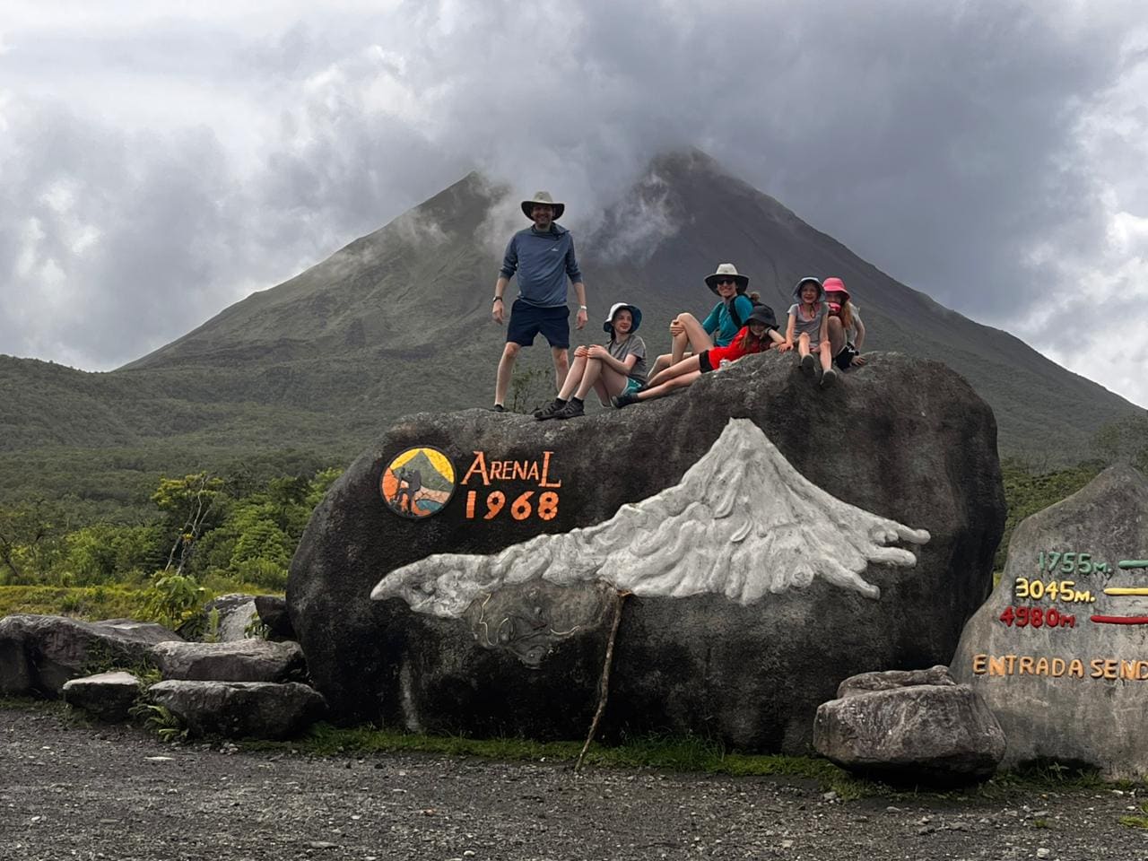 Guide and travelers at the Arenal 1968 trail with the volcano behind them